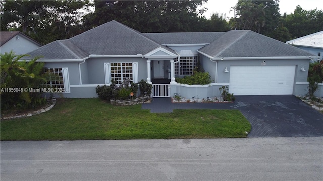 ranch-style home featuring a front lawn and a garage