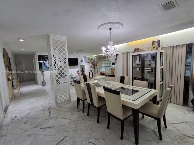 dining space featuring a textured ceiling and a chandelier