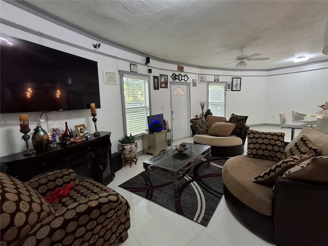 living room with a textured ceiling, ceiling fan, and tile patterned floors