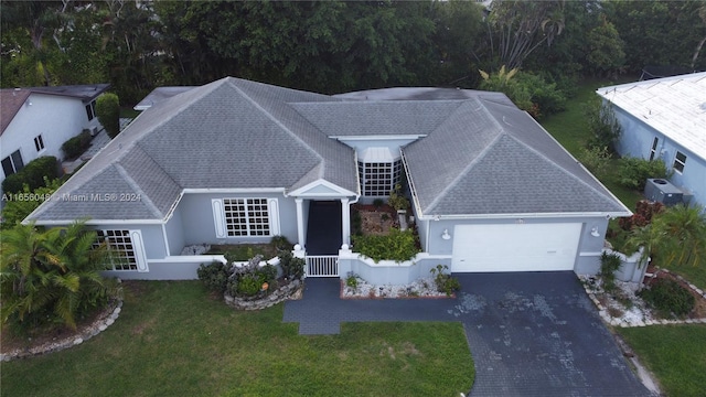 view of front of property with central AC unit, a garage, and a front yard