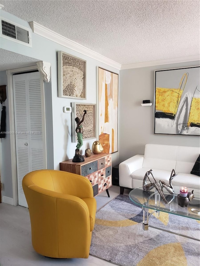 living room with crown molding and a textured ceiling