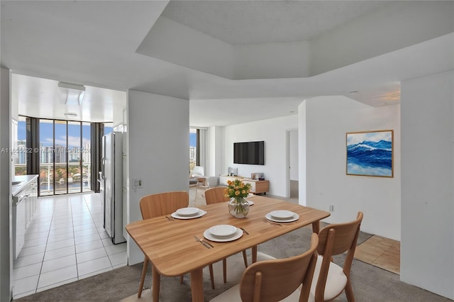 dining area featuring expansive windows and light tile patterned floors