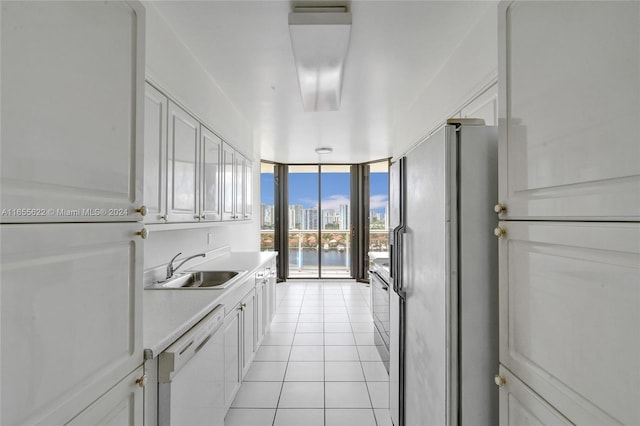 kitchen with stainless steel fridge, white cabinetry, light tile patterned floors, and white dishwasher