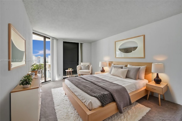 carpeted bedroom featuring floor to ceiling windows and a textured ceiling