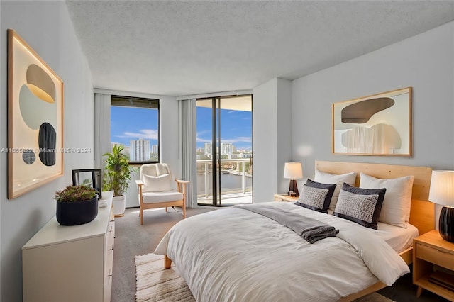 carpeted bedroom featuring a wall of windows, access to outside, and a textured ceiling