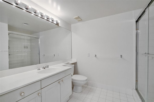 bathroom featuring vanity, toilet, an enclosed shower, and tile patterned floors