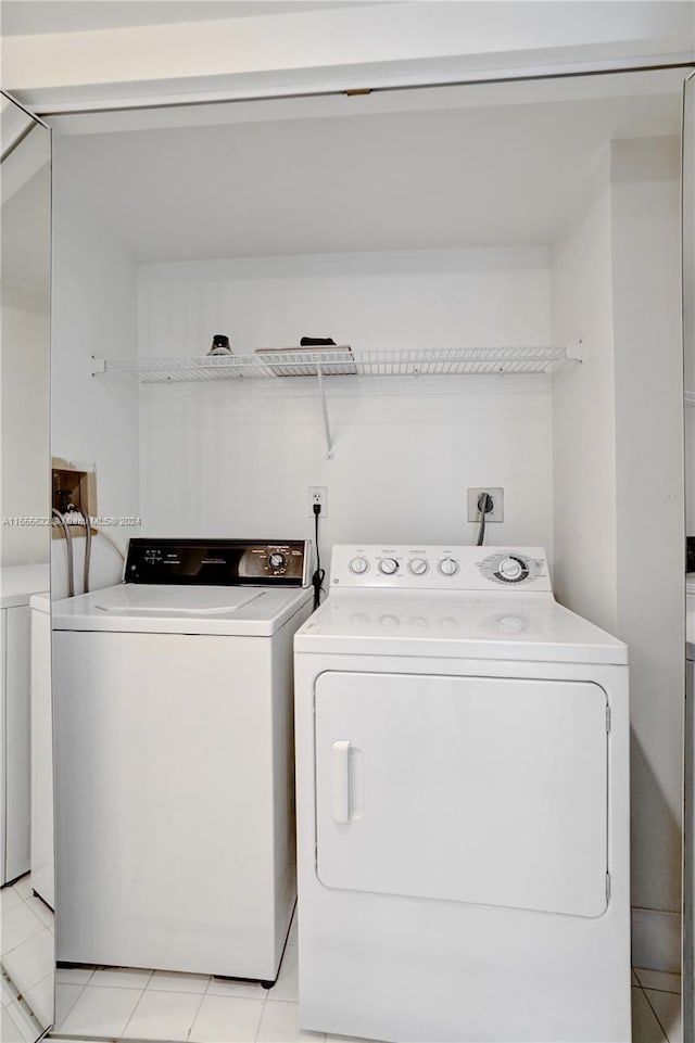 laundry room featuring light tile patterned floors and washer and clothes dryer