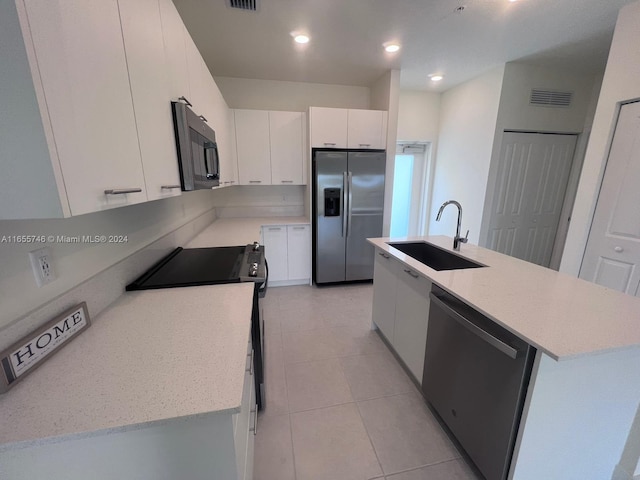 kitchen featuring stainless steel appliances, an island with sink, white cabinetry, and sink