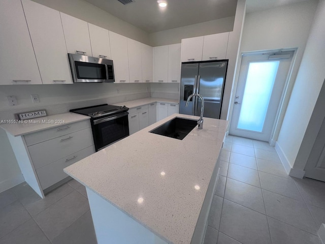 kitchen featuring a center island with sink, sink, appliances with stainless steel finishes, and white cabinets