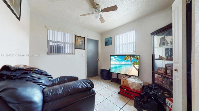 tiled living room featuring a textured ceiling and ceiling fan