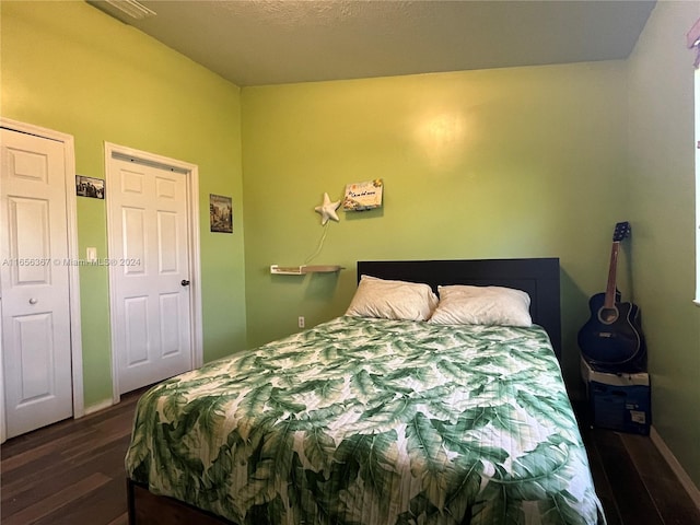 bedroom with dark hardwood / wood-style floors