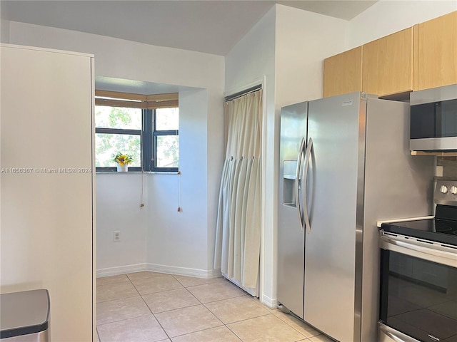 kitchen with stainless steel appliances and light tile patterned flooring