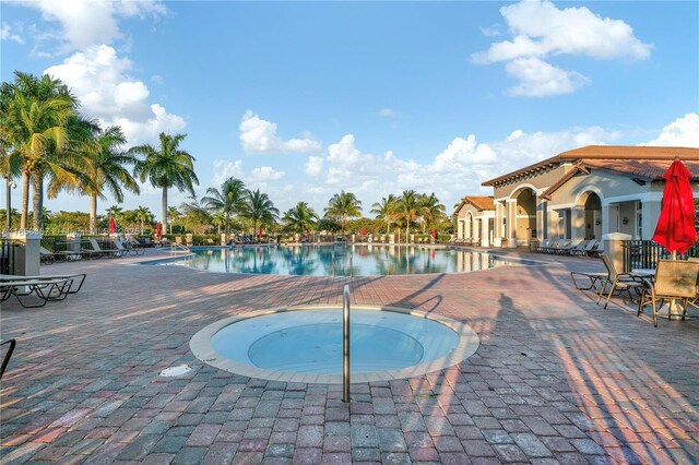 view of pool with a community hot tub and a patio area