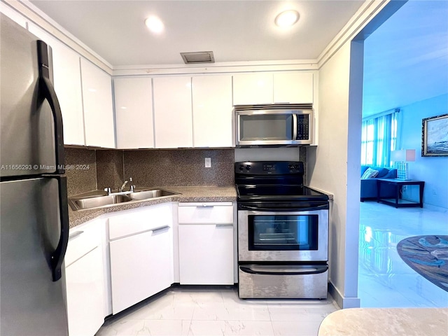 kitchen featuring white cabinetry, sink, appliances with stainless steel finishes, and tasteful backsplash