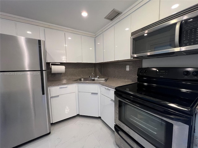 kitchen featuring decorative backsplash, white cabinetry, sink, and appliances with stainless steel finishes