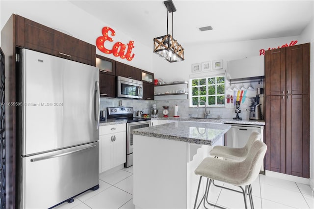 kitchen featuring a center island, vaulted ceiling, appliances with stainless steel finishes, and decorative backsplash