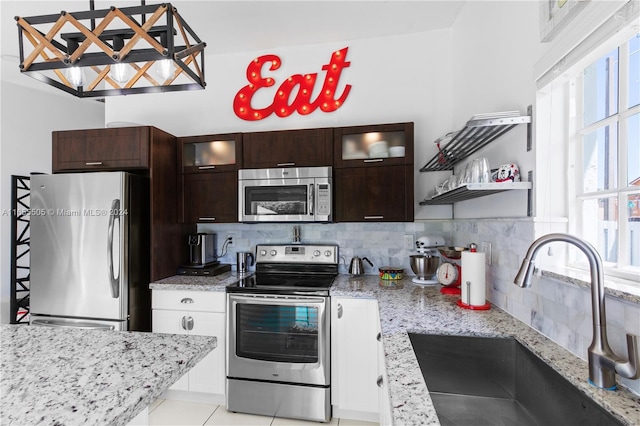 kitchen featuring tasteful backsplash, plenty of natural light, stainless steel appliances, and sink