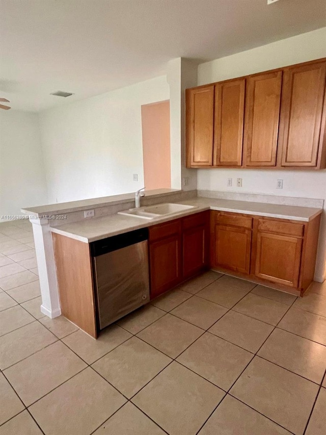 kitchen with kitchen peninsula, dishwasher, light tile patterned flooring, and sink