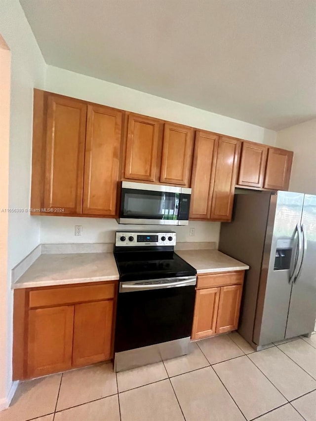 kitchen featuring light tile patterned floors and appliances with stainless steel finishes