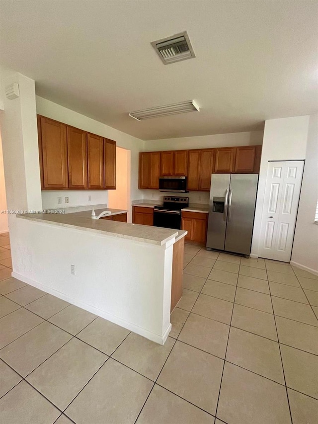 kitchen featuring sink, kitchen peninsula, stainless steel appliances, and light tile patterned floors