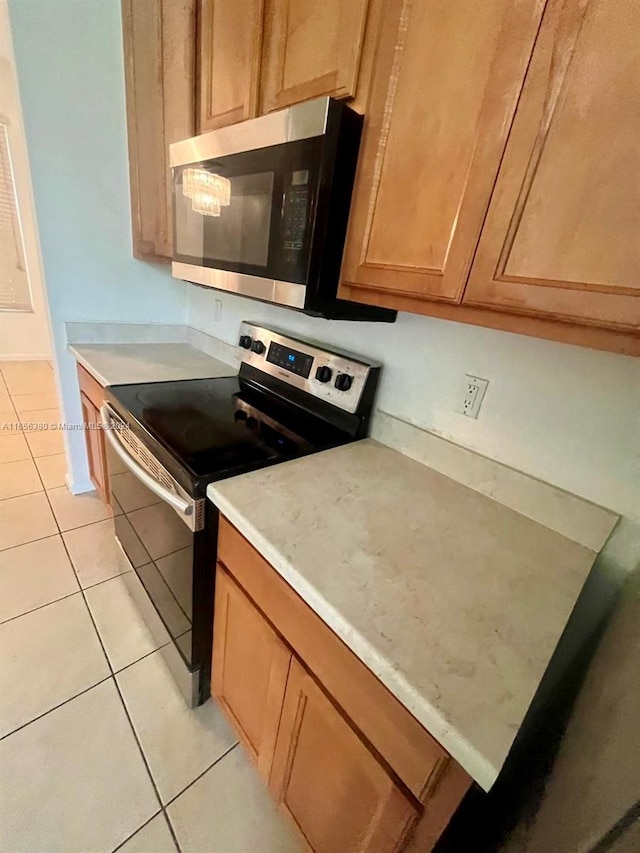 kitchen featuring black / electric stove and light tile patterned flooring