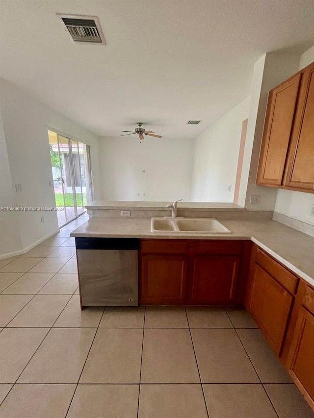 kitchen featuring sink, stainless steel dishwasher, ceiling fan, light tile patterned floors, and kitchen peninsula