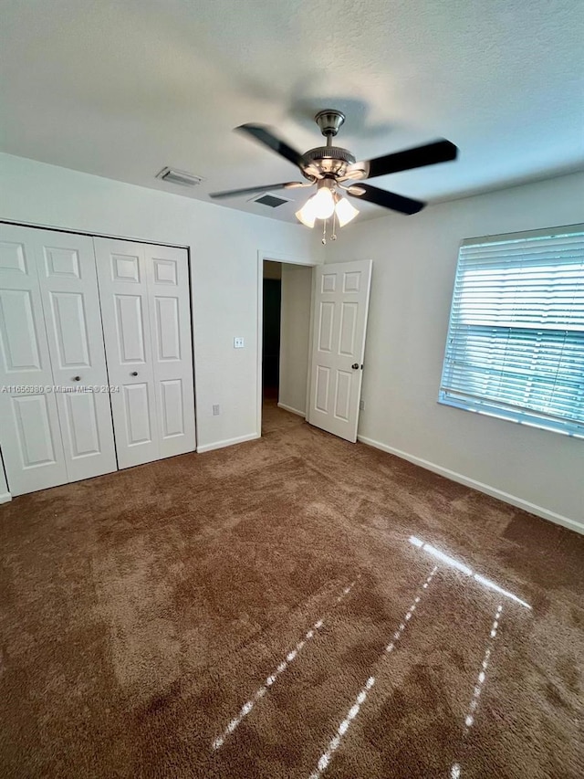 unfurnished bedroom with carpet flooring, ceiling fan, and a closet