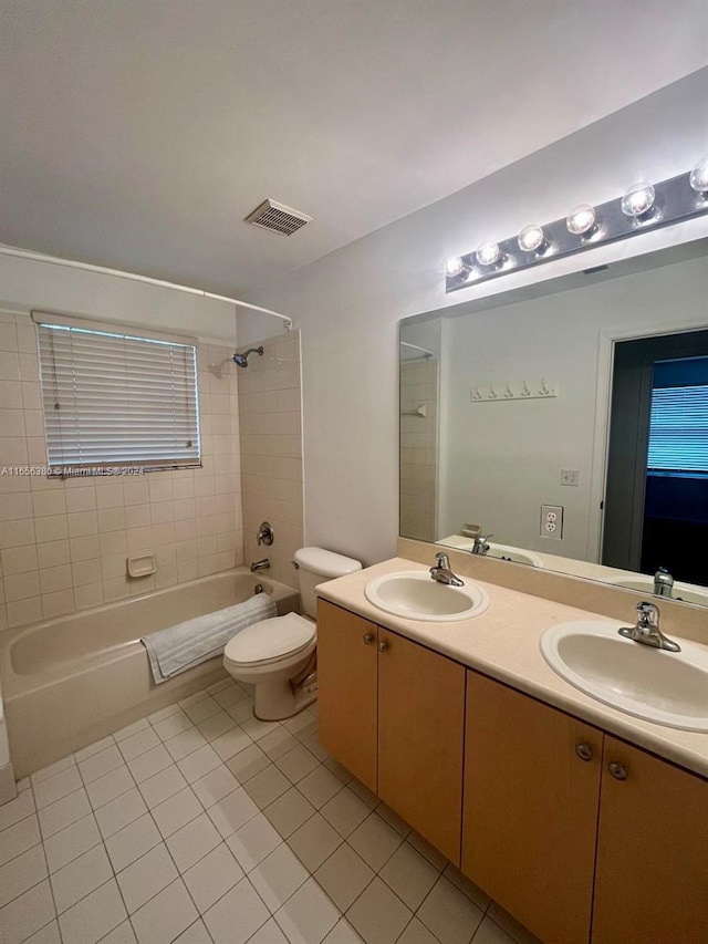 full bathroom featuring toilet, tile patterned flooring, vanity, and tiled shower / bath