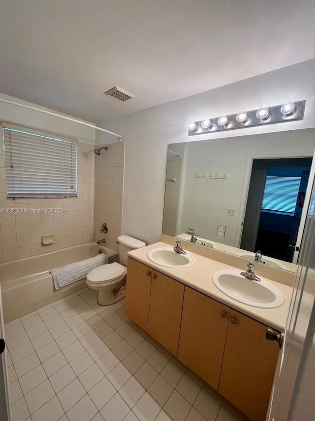 full bathroom featuring toilet, vanity, tile patterned floors, and tiled shower / bath