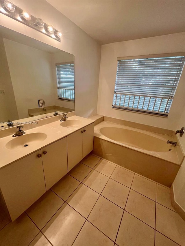 bathroom with a tub to relax in, tile patterned flooring, and vanity