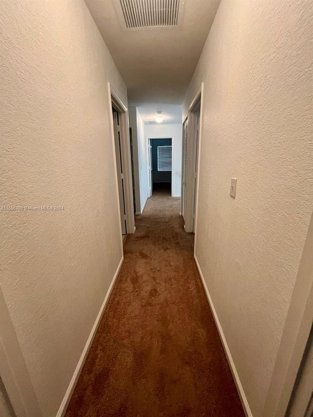 hall featuring carpet flooring