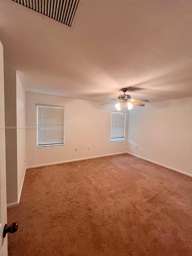 carpeted empty room featuring ceiling fan and a textured ceiling