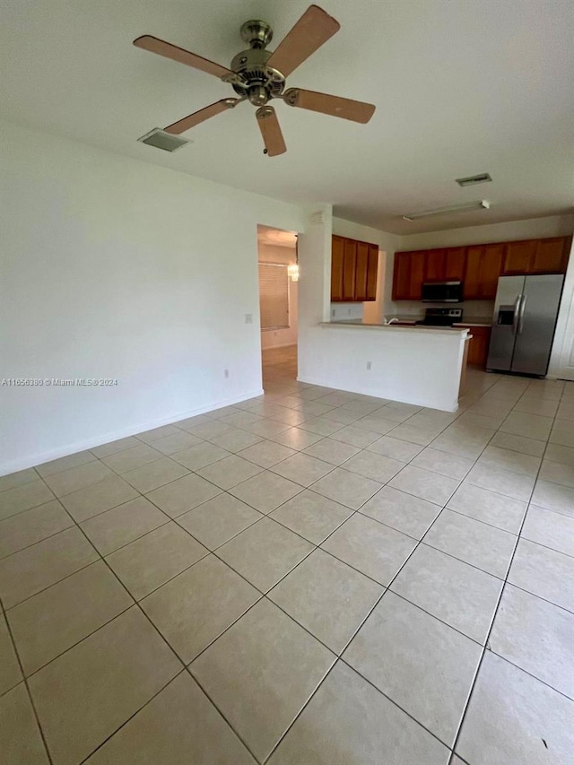 unfurnished living room featuring ceiling fan and light tile patterned flooring