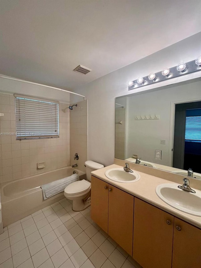 full bathroom with toilet, vanity, tile patterned floors, and tiled shower / bath