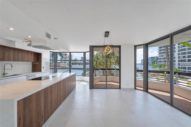 kitchen featuring pendant lighting, plenty of natural light, black electric cooktop, and sink