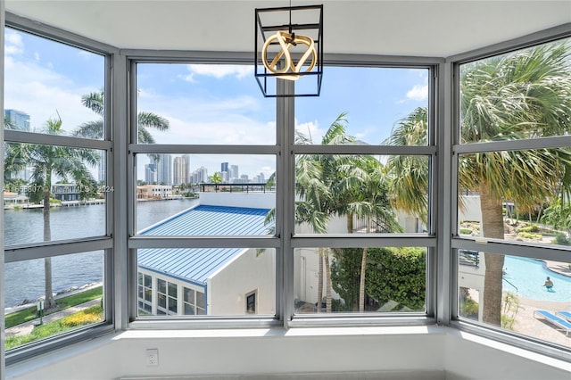 interior space with a notable chandelier and a water view