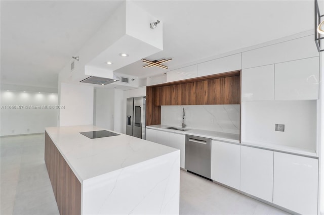 kitchen with white cabinets, backsplash, light stone countertops, stainless steel appliances, and sink