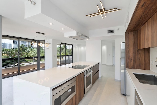 kitchen featuring appliances with stainless steel finishes, sink, a large island, pendant lighting, and exhaust hood