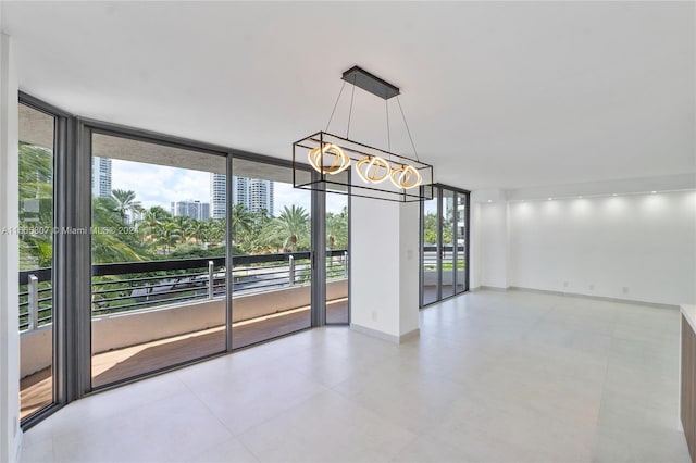 unfurnished room featuring an inviting chandelier and expansive windows