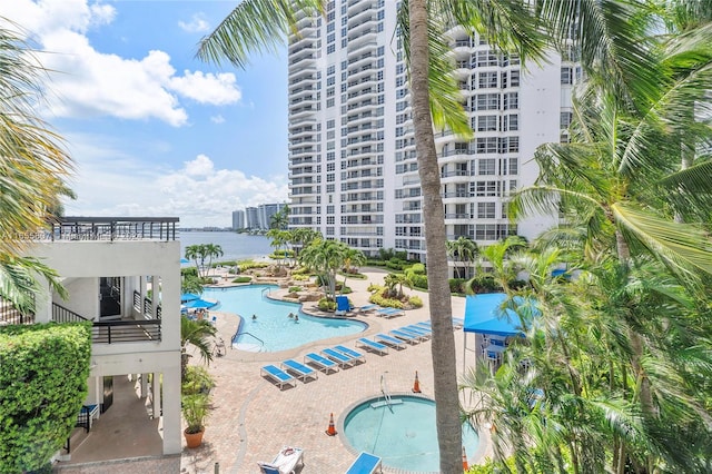 view of pool featuring a water view and a patio area