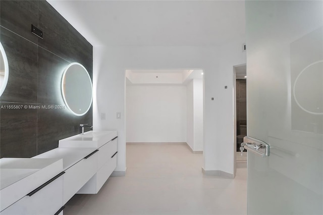 bathroom featuring vanity and tile walls