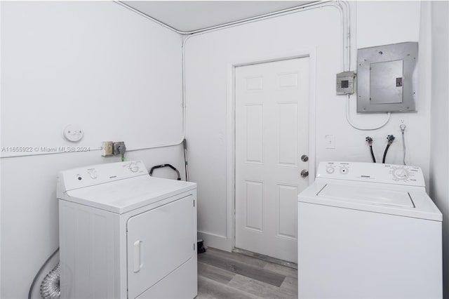 laundry room featuring separate washer and dryer, light hardwood / wood-style flooring, and electric panel