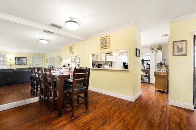 dining area featuring wood finished floors, visible vents, and ornamental molding