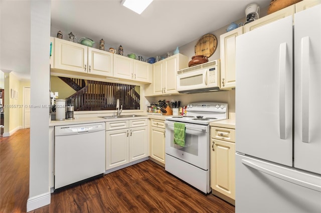 kitchen featuring dark wood-type flooring, white appliances, and sink