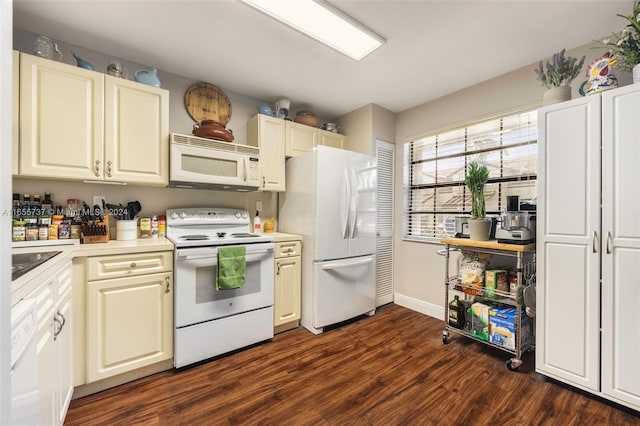 kitchen with dark wood-style floors, light countertops, a sink, white appliances, and baseboards