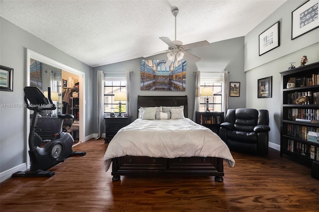 bedroom featuring lofted ceiling, dark wood-type flooring, ceiling fan, and a textured ceiling