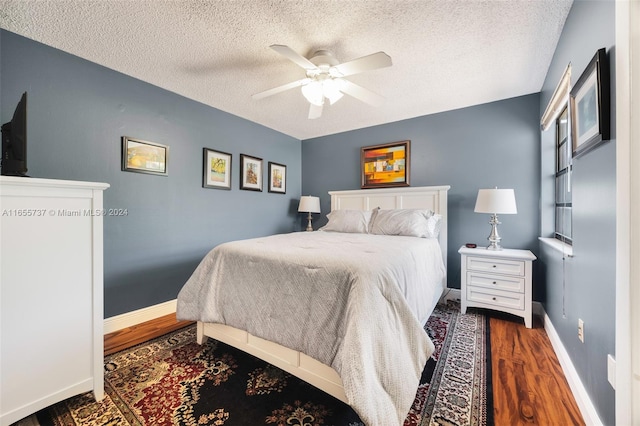 bedroom with a textured ceiling, ceiling fan, and dark hardwood / wood-style flooring