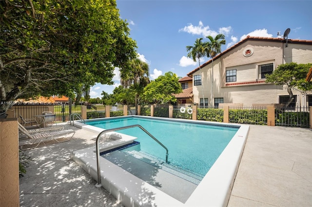 pool featuring fence and a patio