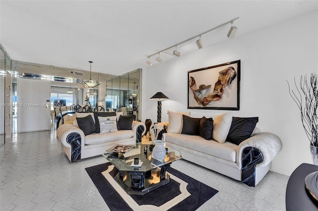 living room with light tile patterned floors, a textured ceiling, and track lighting