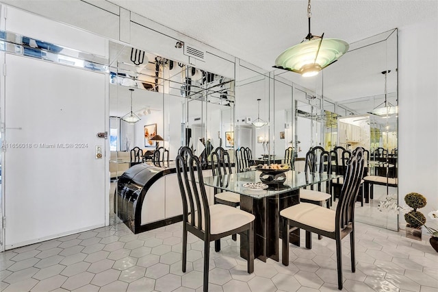 tiled dining room with a textured ceiling